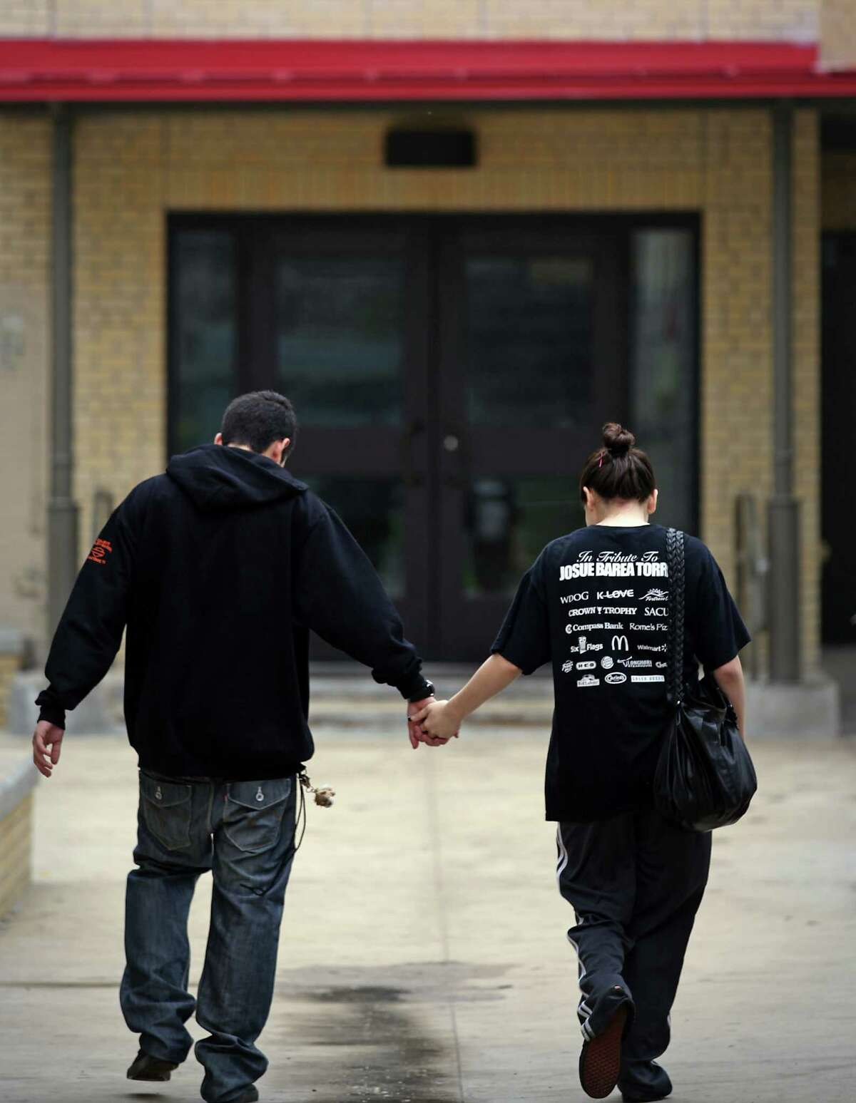 Miranda Berdecia, right, a 17 yr old mother, walks with Jesse Vasquez, the father of her baby, to Healy Murphy where they are finishing up their high school degrees, Thursday, Feb. 2, 2012. Bob Owen/Express-News