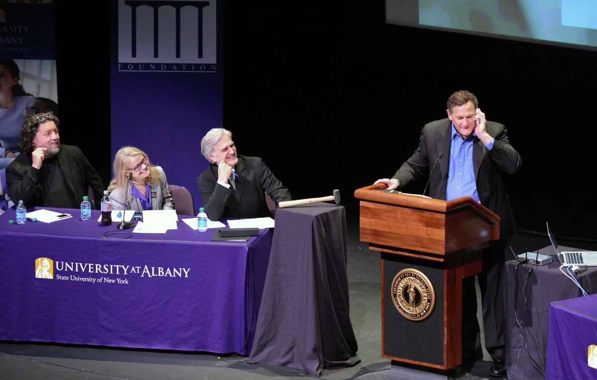 Co-founder of Tribeca Film Festival, Craig Hatkoff, at right, takes a cell phone call during a panel discussion on local film production at UAlbany Thursday May 3, 2012. From left are Philip Morris, CEO of Proctors, Patricia Swinney Kaufman, executive director of the New York State Governor's Office for Motion Picture and Television Development and Times Union editor Rex Smith. (John Carl D'Annibale / Times Union)