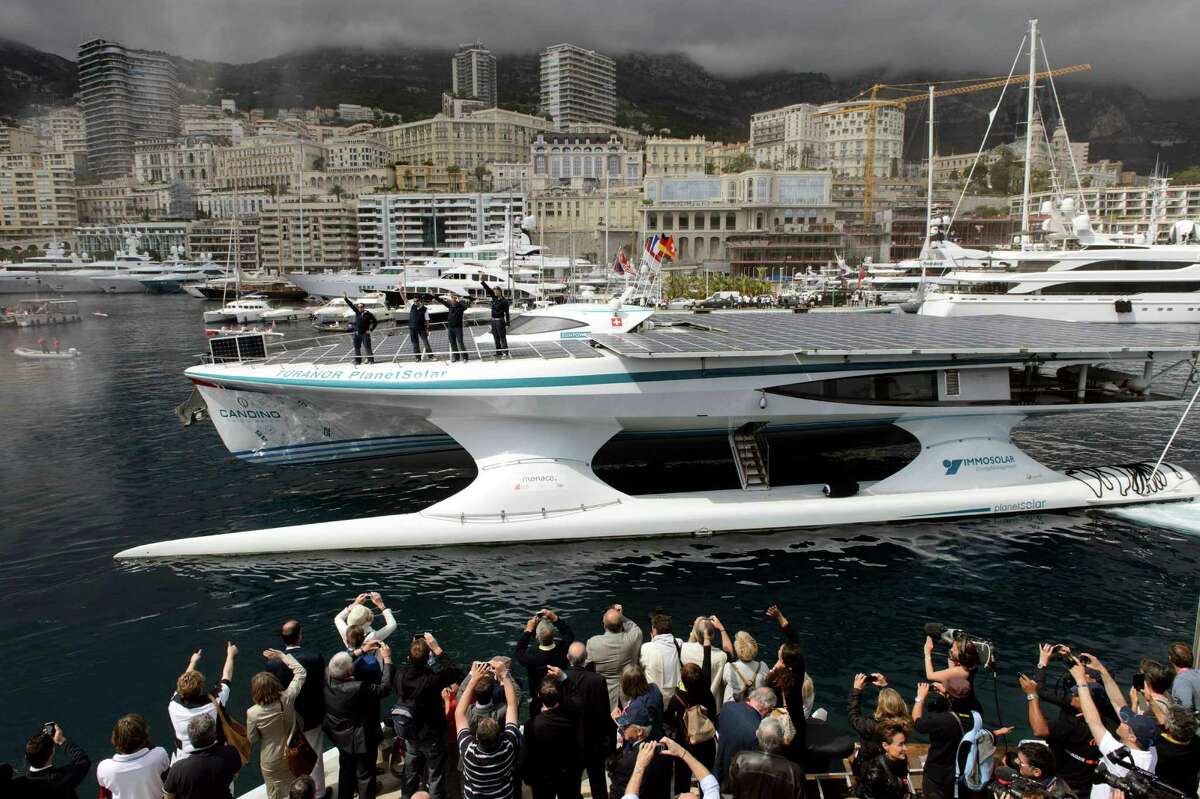 The Swiss-registered solar-powered vessel, MS Turanor PlanetSolar, arrives after crossing the finish line of its trip around the world at the Hercule Harbour in Monaco, Friday, May 4, 2012. MS Turanor PlanetSolar is the biggest solar boat catamaran in the world, with its 537 square meters of photovoltaic panel power 6 blocks of lithium-ion battery, accomplished on Friday the first around the world trip only powered by solar energy, as it has taken since September 2010 to complete the global circumnavigation for this hi-tech vessel to demonstrate the potential of solar energy. (AP Photo/Keystone, Laurent Gillieron)