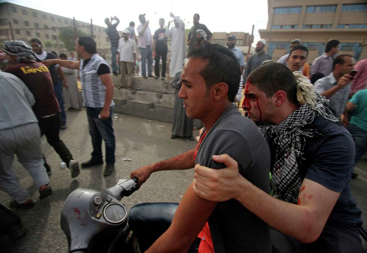 An injured protester is evacuated by motorbike from the site of clashes outside the Ministry of Defense in Cairo, Egypt, Friday, May 4, 2012. Egyptian armed forces and protesters clashed in Cairo on Friday, with troops firing water cannons and tear gas at demonstrators who threw stones as they tried to march on the Defense Ministry, a flashpoint for a new cycle of violence only weeks ahead of presidential elections. (AP Photo/Ahmed Gomaa)