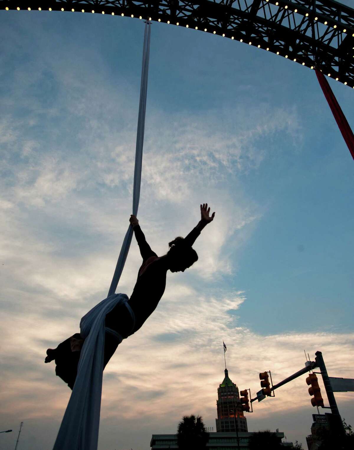 Aerialist Julia Langenberg hangs from the Hemisfair Park arch while practicing for her Luminaria performances, Friday, May 4, 2012.