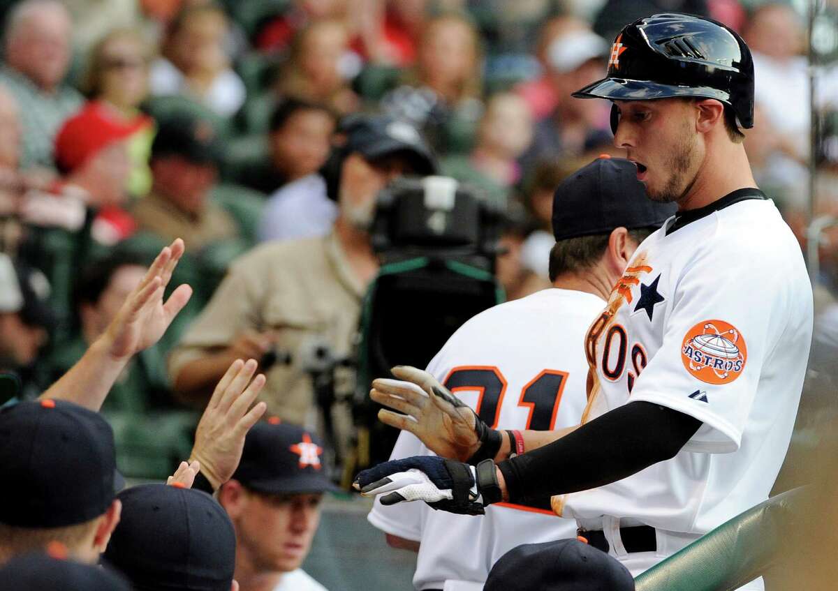 Houston Astros' Jordan Schafer, right, is greeted in the dugout after scoring from third base on a single by Carlos Lee against the St. Louis Cardinals in the first inning of a baseball game, Friday, May 4, 2012, in Houston.
