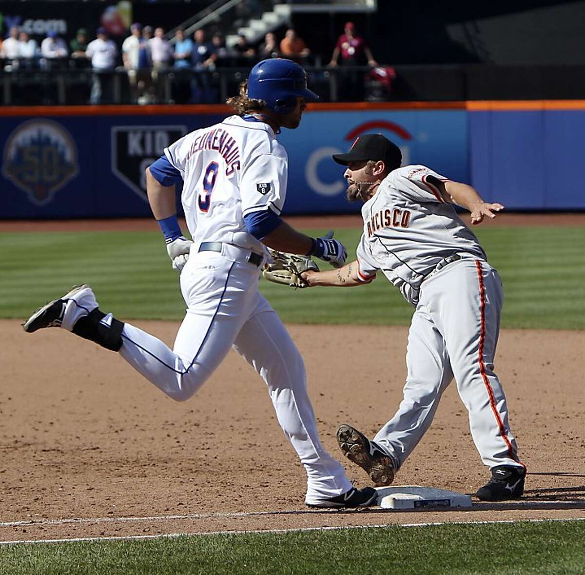 New York Mets' Kirk Nieuwenhuis, left, is safe at first as San Francisco Giants first baseman Aubrey Huff has to step off the base to try for a double play during the ninth inning of a baseball game, Saturday, April 21, 2012, at Citi Field in New York. Because the Giants could not turn the double play, the Mets scored to defeat the Giants 5-4. (AP Photo/Seth Wenig).