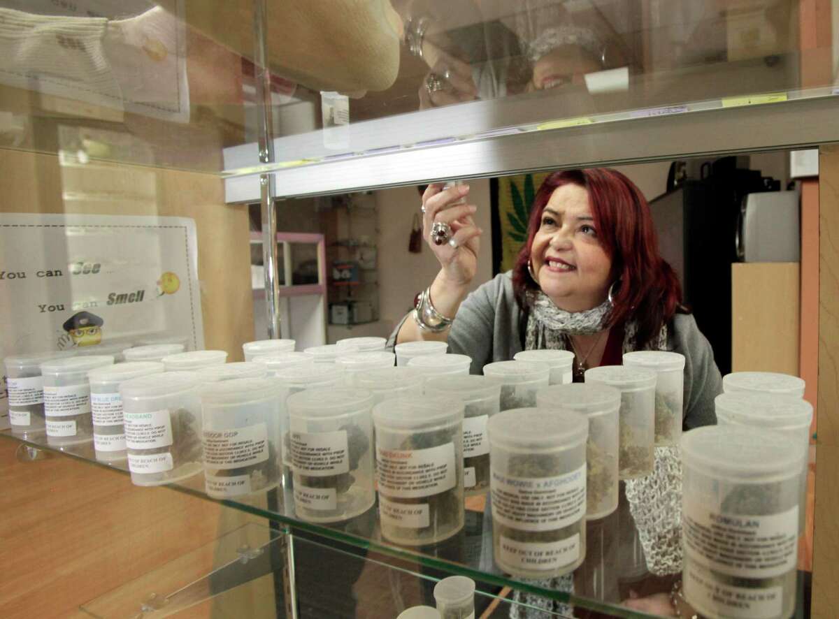 Yamileth Bolanos, who runs Pure Life Alternative Wellness Center, selects a vial of marijuana for a client at her store in Los Angeles Tuesday, Jan. 26, 2010. The day feared by medical marijuana advocates arrived Tuesday when the City Council approved an ordinance intended to close hundreds of pot shops and banish those that remain to industrial areas. Bolanos said she'll have to close her clinic to comply with the new restrictions, then reopen at a new location nine miles away. The new law, which passed 9-3, caps the eventual number of dispensaries in the city at 70. (AP Photo/Reed Saxon)