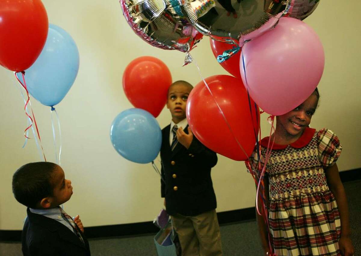 Siblings, from left to right, Peter Vega-Cross, 2, Krystofer Joyner-Cross, 4, and Angelica Joyner-Cross,5, attend a post adoption party after a ceremony conducted by Judge Paul Ganim in McLevy Hall in Bridgeport on Nov. 20, 2009. The children were adopted by Winsome and Edward Cross.