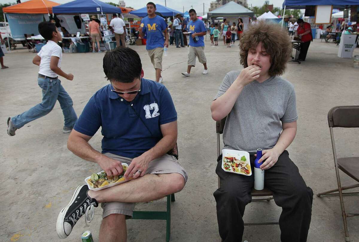 Joel Brotzman and Tim Chalt eat tacos from Monterey Taqueria as a handful of vendors battle for "The Best Taco Truck".