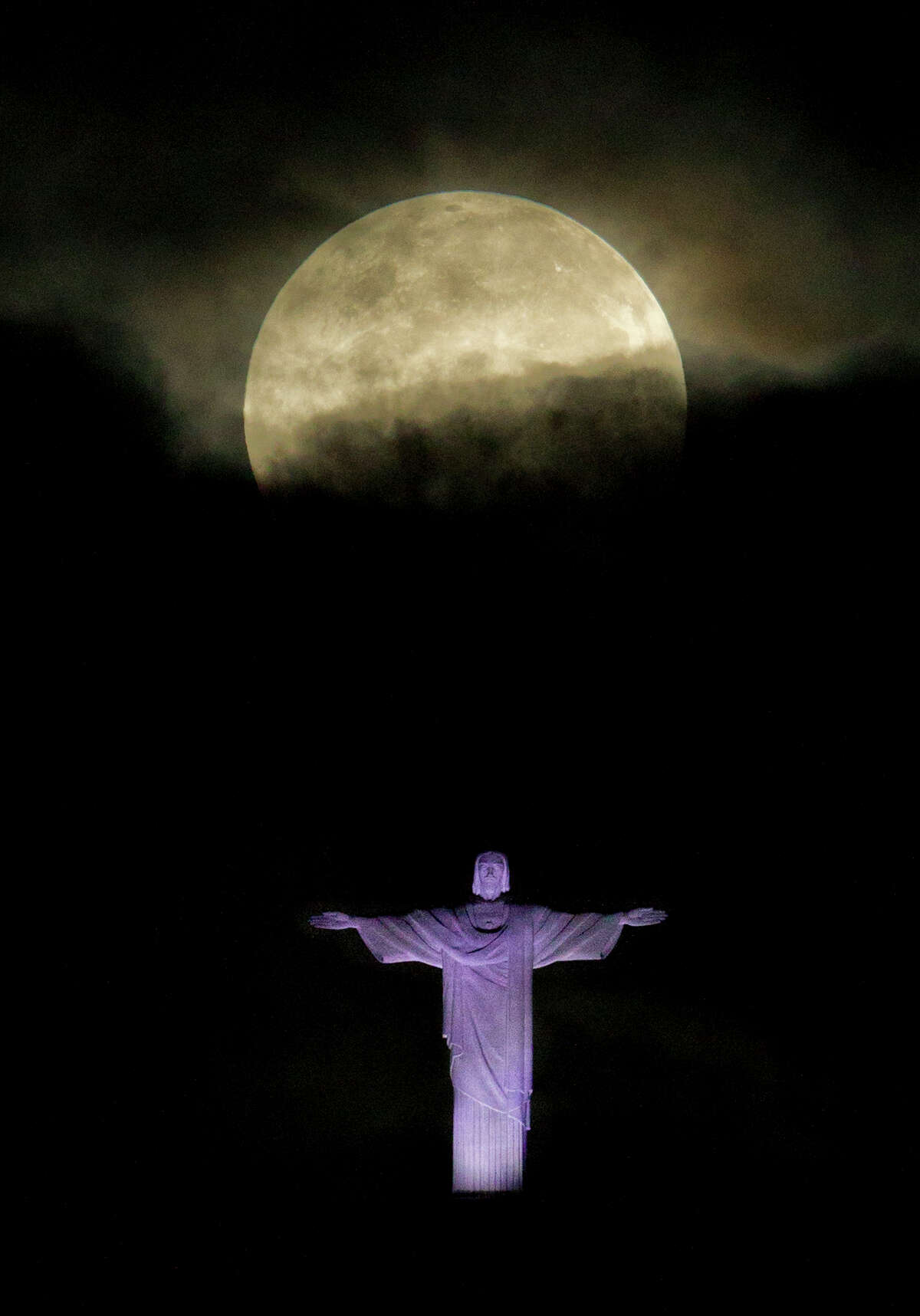 The "supermoon" appears above the Christ the Redeemer statue in Rio de Janeiro, Sunday, May 6, 2012. The moon was the closest it will get to the Earth this year _ and appeared 14 percent larger because of that. At its peak it was about 221,802 miles from Earth. (AP Photo/Victor R. Caivano)