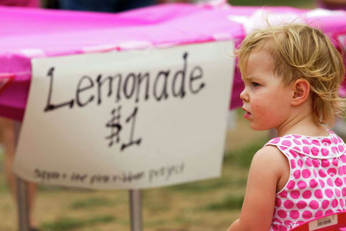 Jenna Hensley sits at a lemonade stand in Memorial Park during Lemonade Day Sunday, May 6, 2012, in Houston. Youths from across the city set up lemonade stands, to learn how to start, own and operate their own business. This stand benefitted the Pink Ribbon Project.
