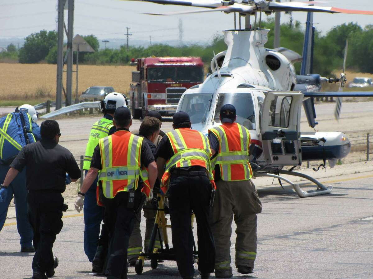 Emergency workers roll a young girl on a stretcher to an awaiting medical helicopter after a rollover crash on the Southwest Side on Sunday, May 6, 2012.
