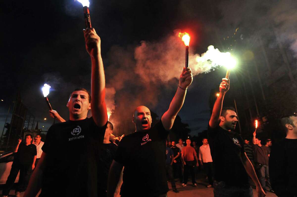 Extremist Golden Dawn party supporters brandish flares as vote results are revealed in the Greek port city of Thessaloniki on Sunday.
