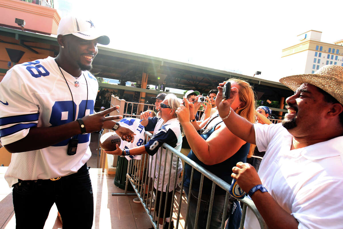 Cowboys receiver Dez Bryant stops to let fan Joe Perez (right) take a photo during the team’s Fan Fest at Sunset Station.