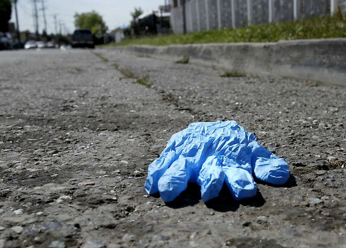 A paramedics glove lays on Birch Street at the scene of the shooting. A shootout that erupted near 92nd Avenue and Birch Streets in Oakland, Calif. wounded an Oakland policeman and killed the suspect Sunday May 6, 2012.