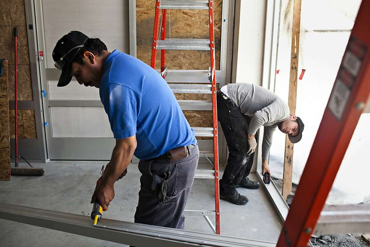Dan Casey, right, and Raul Ayala, left, of KC Glass, work on the construction of a new Walgreens store on the corner of Jones and Bay Streets in San Francisco, Calif., Thursday, April 26, 2012. The pharmacy chain store is under construction in the location of the old Tower Records store near Fisherman's Wharf, a spot that's two blocks from not one, but two, other Walgreens. There are the eight within a mile-and-a-half radius and 67 total in San Francisco. Jason Henry/Special to The Chronicle
