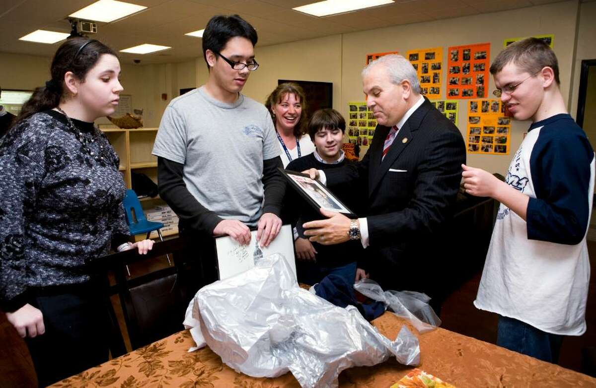 Lt. Gov. Michael Fedele, second from right, is presented with a gift by Stamford High School students Olivia Shea, left, Arrian Velasco, second from left, Anthony Portanova, center, and Mickey Teuburt, right. Their teacher, Sheree Cook, looks over their shoulders, third from left. Fedele was at the school to visit a new, specially designed Autism Disorder Spectrum classroom.