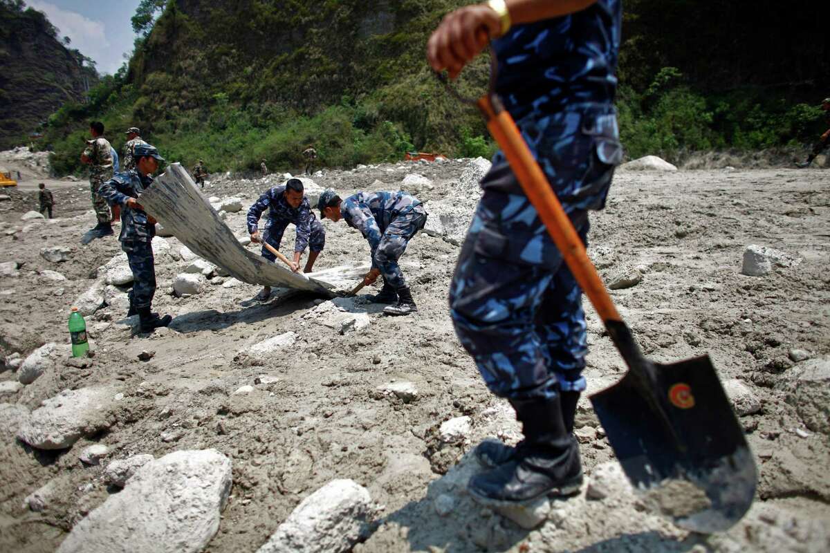 Nepalese rescuers search through mud and debris after a flash flood in the Seti river at Kharapani village of Kaski district, about 200 kilometers (125 miles) west of capital Katmandu, Nepal, Monday, May 7, 2012. Rescuers searching through mud and debris for flash-flood victims in northwestern Nepal had found 17 bodies by Monday, police said. Another 47 people, including three Ukrainian tourists, were missing and presumed dead.(AP Photo/Niranjan Shrestha)
