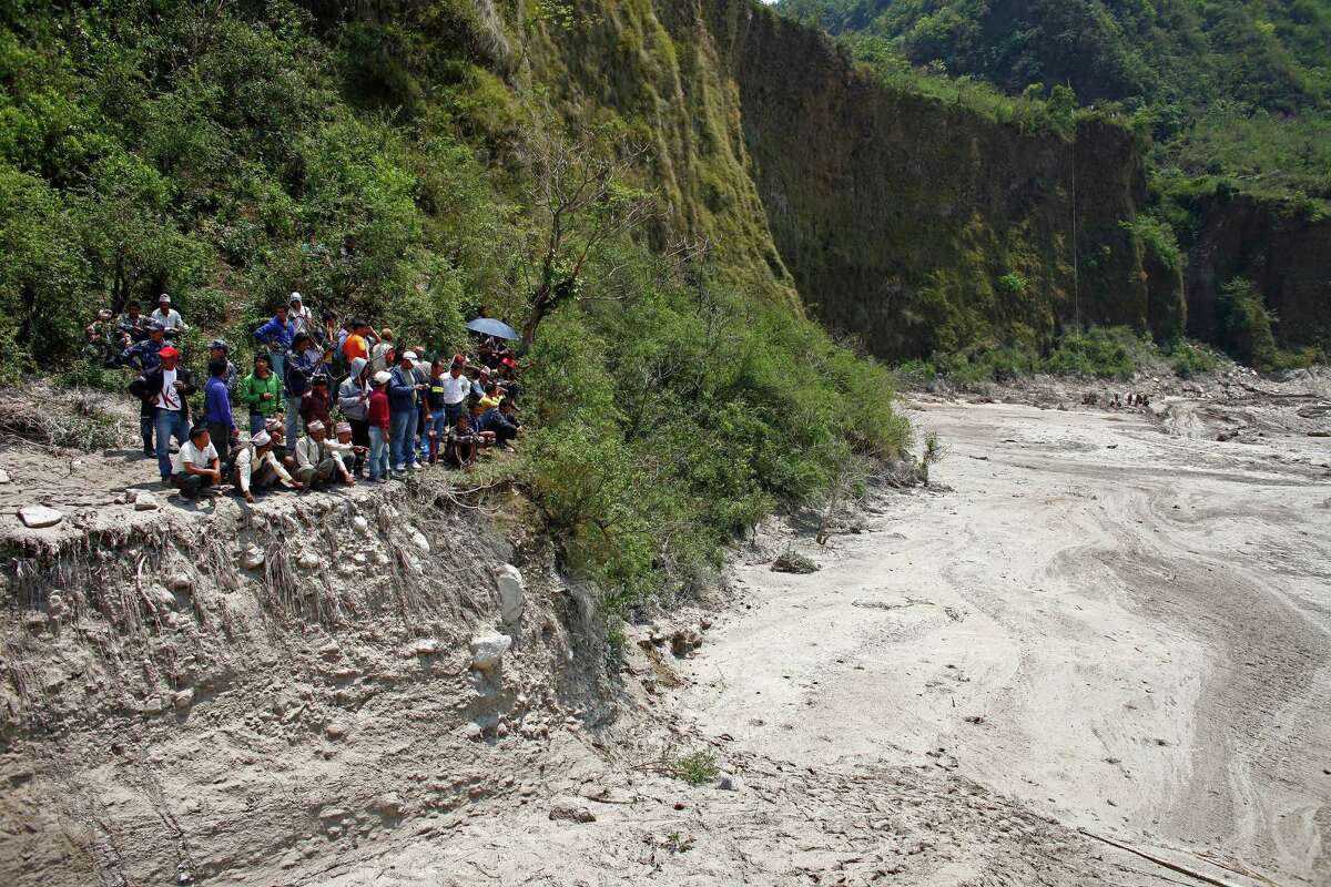 Nepalese villagers look at the site of a flash flood at Kharapani village of Kaski district, about 200 kilometers (125 miles) west of Katmandu, Nepal, Sunday, May 6, 2012. Flash floods from the Seti river in western Nepal swept away dozens of people along with their cattle and houses, officials said. Bodies have been recovered, a police official said. (AP Photo/Niranjan Shrestha)