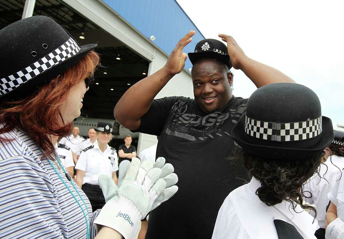 James White, a member of the TSA team, trys on a hat belonging to a female member of London's Metrpolitan Police Services after his team pulled a Jet Blue A320 plane 100 feet during the third annual Jet Blue Airbus A320 Plane Tug at JFK Airport on May 7, 2012 in New York City. Members of the London's Metropolitan Police Services went head-to-head with local law enforcement and airport crewmembers to see which team of up to 16 people could pull a 150,000 pound Jet Blue A320 aircraft 100 feet in the fastest time. A team of TSA employees had the fastest time of 32 seconds. The "Brits VS Yanks" competition raises money and awareness for the Joining Against Cancer Kids (JACK) Foundation, a UK based organization that rase money for Neuroblastoma cancer research.