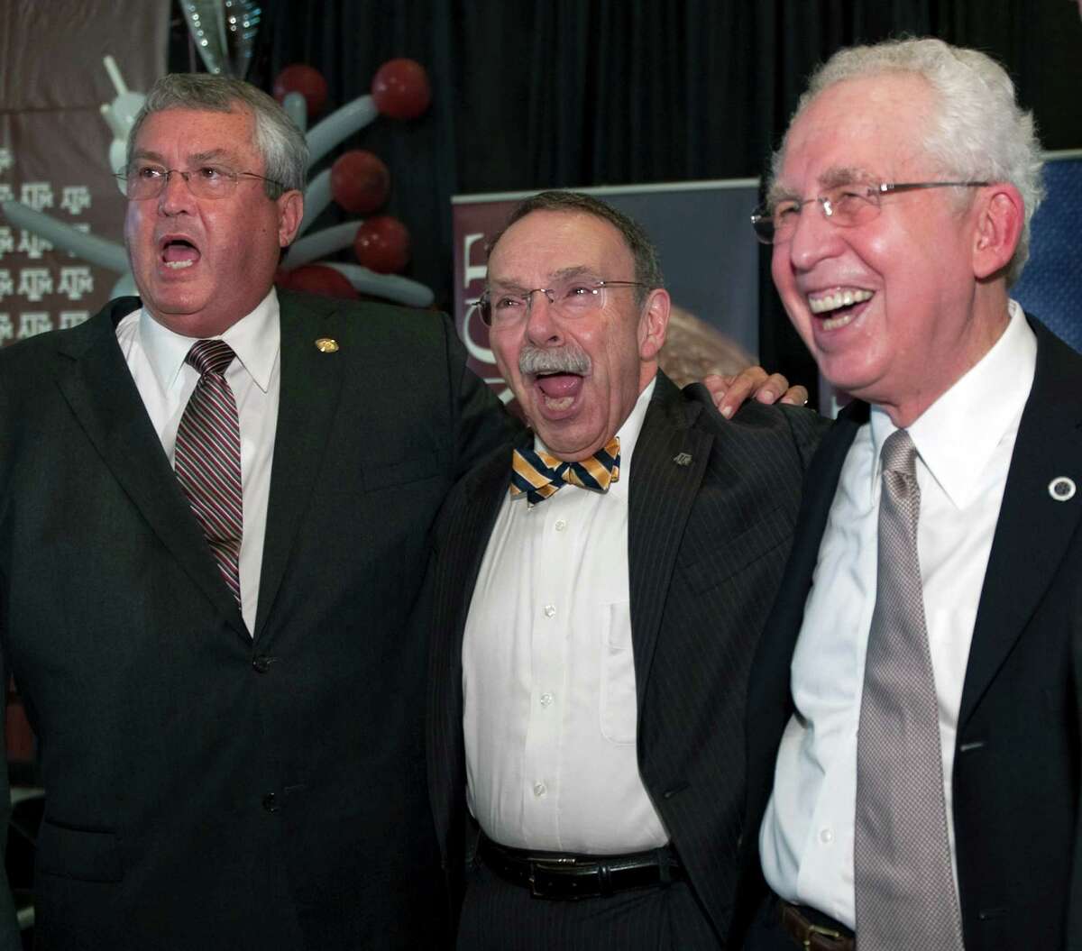 Texas A&M athletic director Bill Byrne, left, A&M president R. Bowen Loftin, center, and Southeastern Conference commissioner Mike Slive, right, react to the playing of the A&M school song during a celebration of A&M's move to the Southeastern Conference Monday, Sept. 26, 2011, in College Station, Texas. (AP Photo/Dave Einsel)