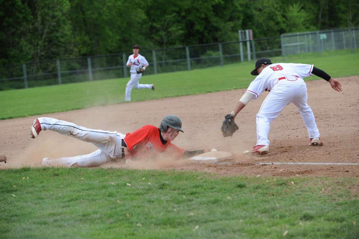 New Canaan High School's # 21, Grady Amrhein slides onto third base against thirdman Cameron Fennell at baseball, hosted by Greenwich Monday, May 7, 2012. Greenwich High School won 4 to 3 against New Canaan High School.