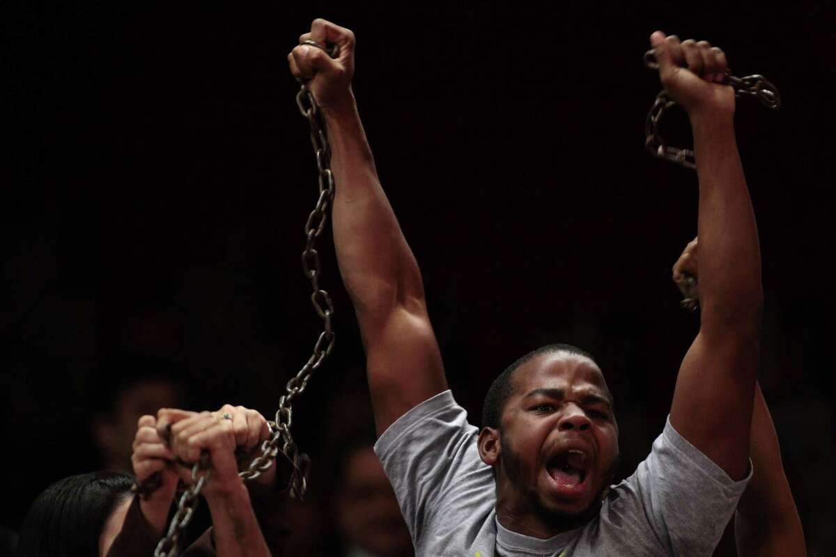 A man holding chains protests slave labor outside the Chamber of Deputies in Brasilia, Brazil, Tuesday, May 8, 2012. Brazil's lower house is expected to vote on a constitutional amendment that would punish landholders found to be using slave labor. The proposed bill would allow the government to confiscate all property of those found to be using slave labor, among other penalties. (AP Photo/Eraldo Peres)