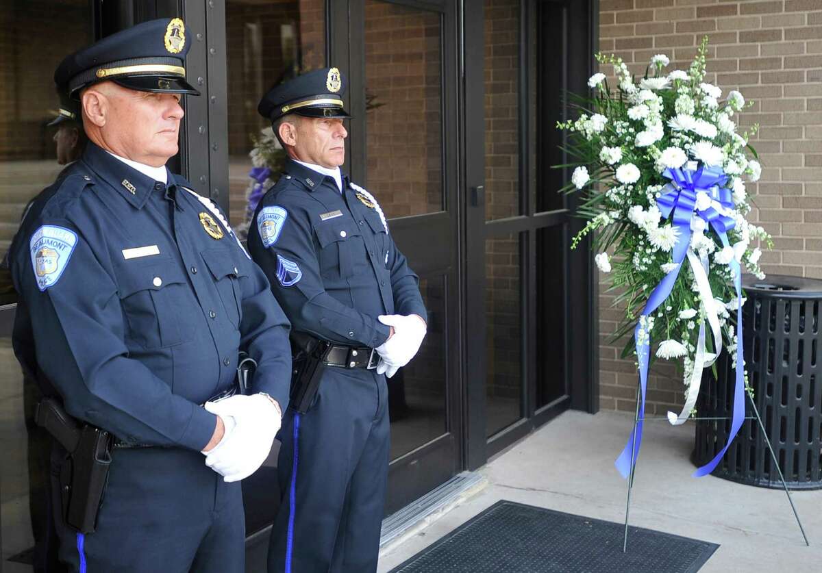 Kolin Burmaster, left, and Sgt. Marc Levy, right, stand with the wreath that would be placed at the base of the memorial. Fallen Beaumont Police Officer Bryan Hebert's badge was added to the police officer memorial in front of the Beaumont Police station on Wednesday morning, May 9, 2012. A new female police officer statue was also unveiled. The 2012 dedication comes the week before National Police Week, when the Hebert family will be in Washington D.C. to attend a national memorial. Dave Ryan/The Enterprise