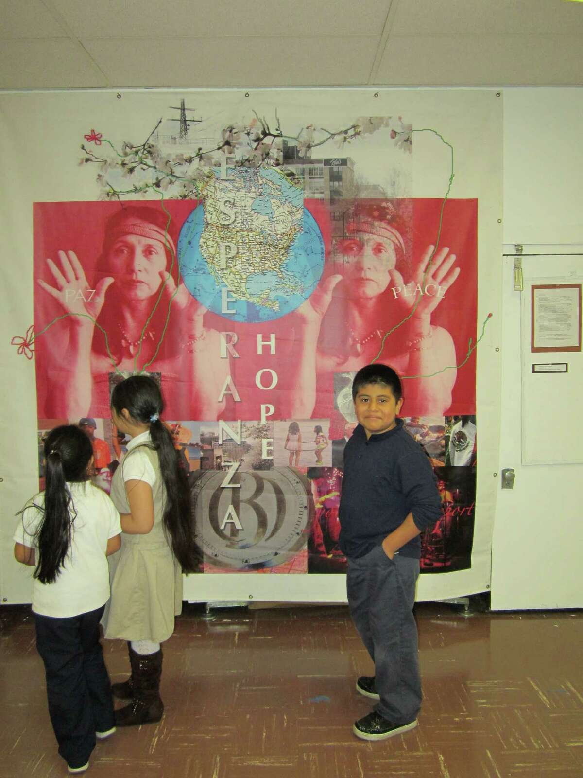 A group of Roosevelt School students view a mural banner by Bridgeport artist Yolanda Petrocelli in the school's art gallery.