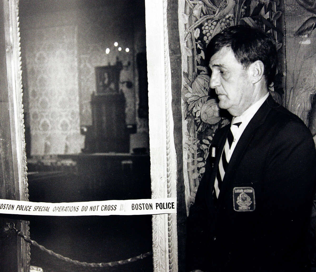 In this March 21, 1990 file photo, a security guard stands outside the Dutch Room of the Isabella Stewart Gardner Museum, where robbers stole more than a dozen works of art in an early morning robbery in Boston. It remains the most tantalizing art heist mystery in the world. In the early hours of March 18, 1990, two thieves walked into Boston's elegant Isabella Stewart Gardner Museum disguised as police officers and bound and gagged two guards using handcuffs and duct tape. For the next 81 minutes, they sauntered around the ornate galleries, removing masterworks including those by Rembrandt, Vermeer, Degas and Manet, cutting some of the largest pieces from their frames. Now, 20 years later, investigators are making a renewed push to recover the paintings.