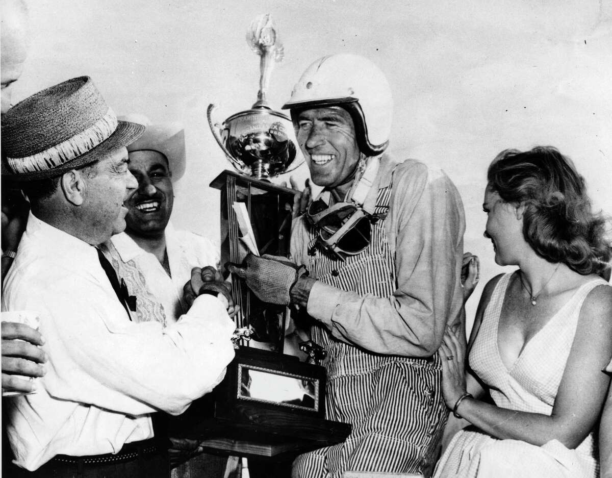 FILE - In this April 3, 1960 file photo, race car driver Carroll Shelby, center, of Dallas, receives his winner's trophy from promotion manager Dave Brandman, after winning the 200-mile International Grand Prix at the Riverside Raceways, in California. At right is Jan Harrison, the queen of the race. Shelby, the legendary race driver and Shelby Cobra sports car designer, has died at age 89. Shelby's company Carroll Shelby International says Shelby died Thursday, May 10, 2012, at a Dallas hospital. He had received a heart transplant in 1990 and a kidney transplant in 1996.