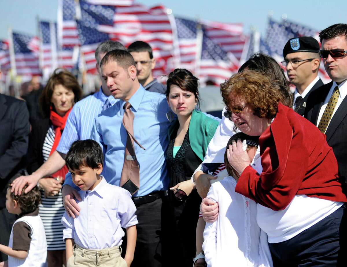 Family members grieve as the body of U.S. Army Capt. Bruce Kevin Clark who died in Afghanistan is carried across the tarmac during Military honors at Rochester International Airport Saturday, May 12, 2012 in Rochester, N.Y. Military officials say Clark's wife, Susan Orellana-Clark, was in Texas Skyping with him on April 30 when he collapsed. Army officials say the investigation into the death is continuing.