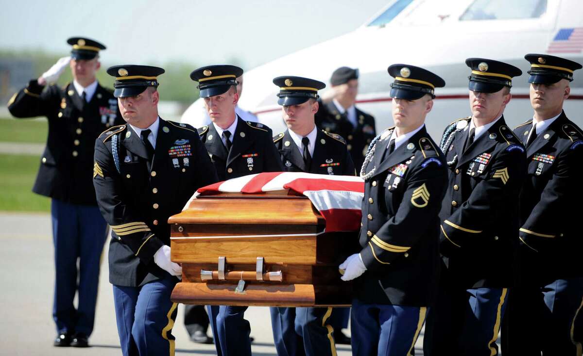 The body of U.S. Army nurse Capt. Bruce Kevin Clark who died in Afghanistan, carried across the tarmac during Military honors at Rochester International Airport Saturday, May 12, 2012.