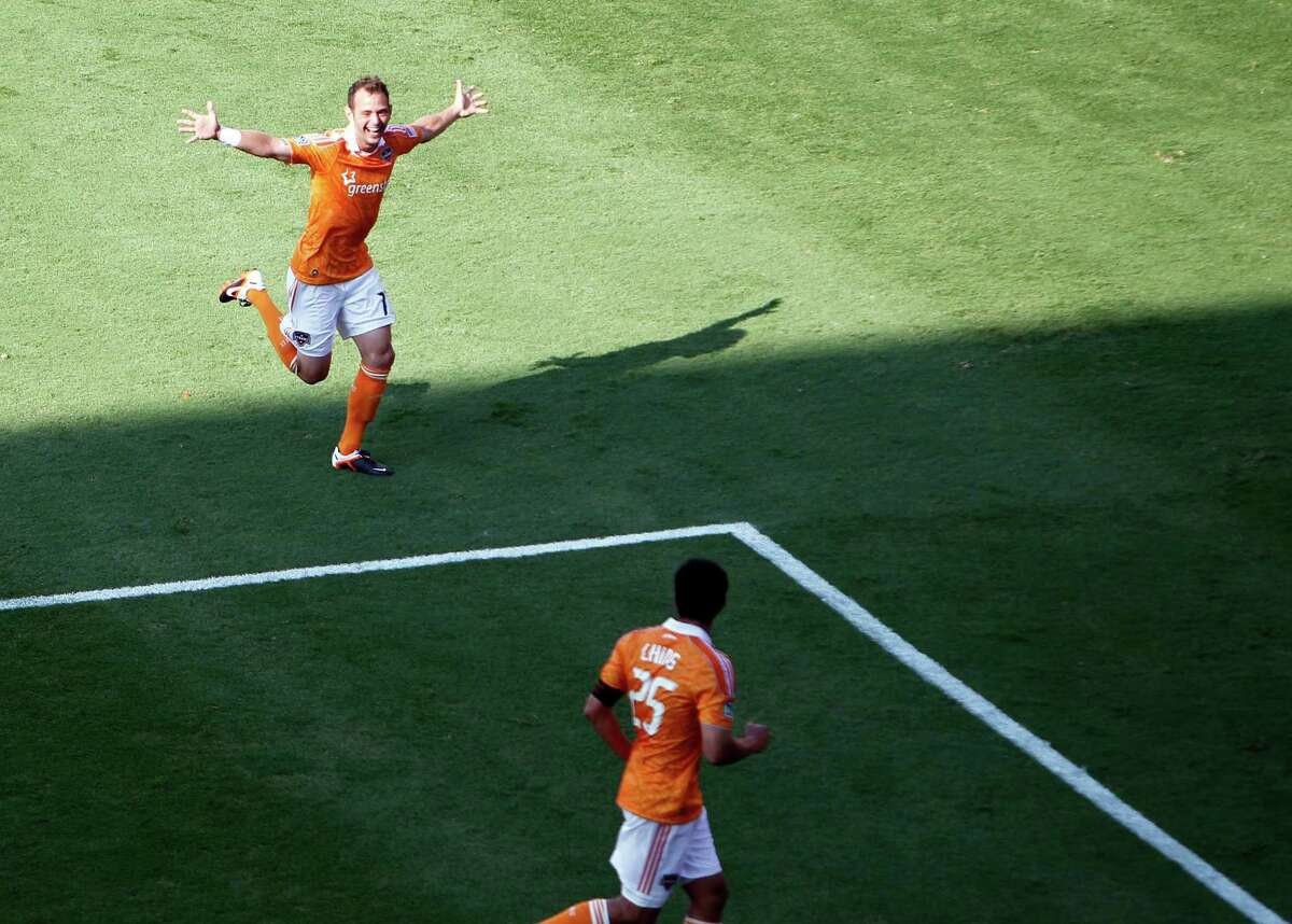 The Houston Dynamo's Brad Davis left celebrates after scoring a goal against the D.C. United during the second half as teammate Brian Ching right, looks on in MLS game action at BBVA Compass Stadium Saturday, May 12, 2012, in Houston.