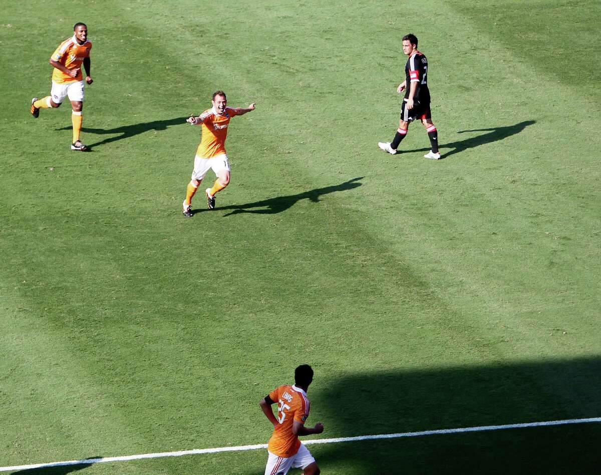 The Houston Dynamo's Brad Davis center celebrates after scoring a goal against the D.C. United during the second half as teammate Jermaine Taylor left, Brian Ching lower right look on in MLS game action at BBVA Compass Stadium Saturday, May 12, 2012, in Houston.