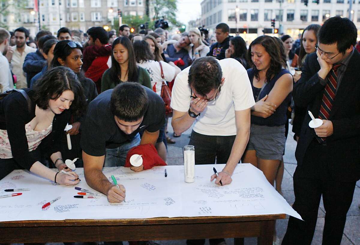 Boston University students gather to sign a condolence note prior to a candlelight vigil on Marsh Plaza at Boston University, Saturday, May 12, 2012, in Boston, for three students studying in New Zealand who were killed when their minivan crashed during a weekend trip. At least five other students were injured in the accident, including one who was in critical condition. Boston University spokesman Colin Riley said those killed in the accident were Daniela Lekhno, 20, of Manalapan, N.J.; Austin Brashears, 21, of Huntington Beach, Calif.; and Roch Jauberty, 21, whose parents live in Paris. (AP Photo/Bizuayehu Tesfaye)
