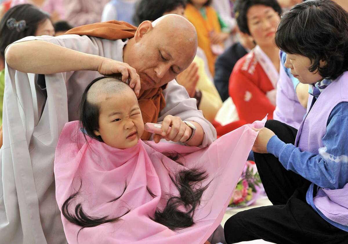 A South Korean boy gets his head shaved by a Buddhist monk during a "Children Becoming Buddhist monks" ceremony at Jogye temple in Seoul on May 13, 2012. The 9 children will stay at the temple to learn about Buddhism for 20 days ahead of celebrations for Buddha's birthday on May 28 this year.