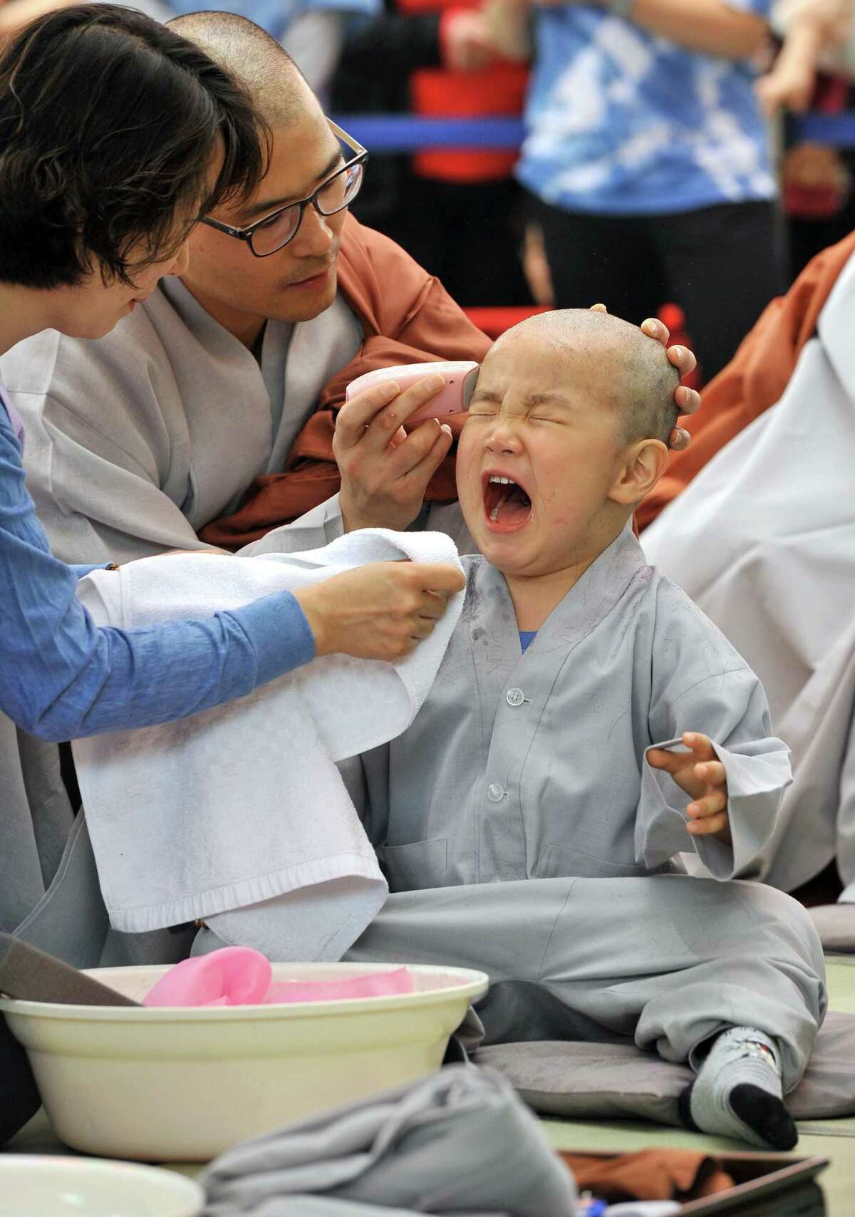 A South Korean boy cries as he gets his head shaved by a Buddhist monk during a "Children Becoming Buddhist monks" ceremony at Jogye temple in Seoul on May 13, 2012. The 9 children will stay at the temple to learn about Buddhism for 20 days ahead of celebrations for Buddha's birthday on May 28 this year.