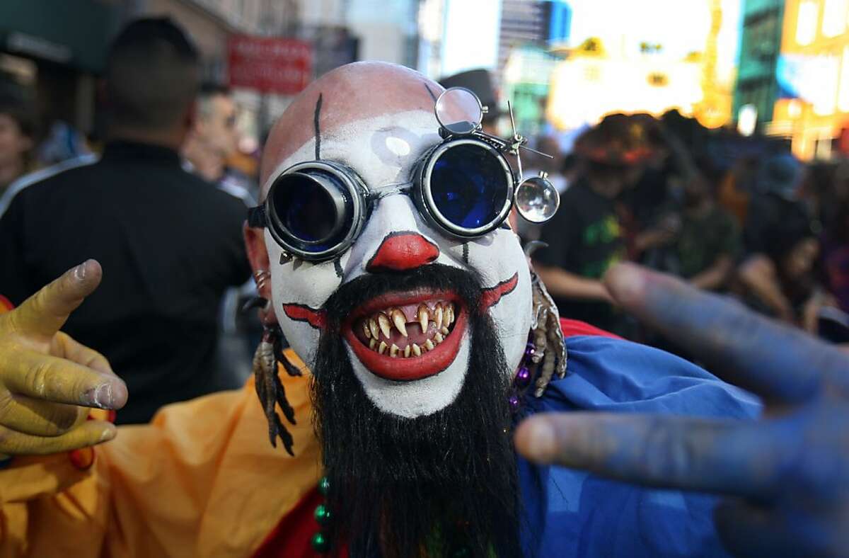 Fred Arrollo, dressed in an elaborate clown costume, dances among a large crowd of people during the How Weird Street Festival in San Francisco on Sunday. Thousands of people dressed in outlandish costumes gathered and 2nd and Howard Street in San Francisco on Monday for music, dancing, and drinks for the annual How Weird Street Festival.
