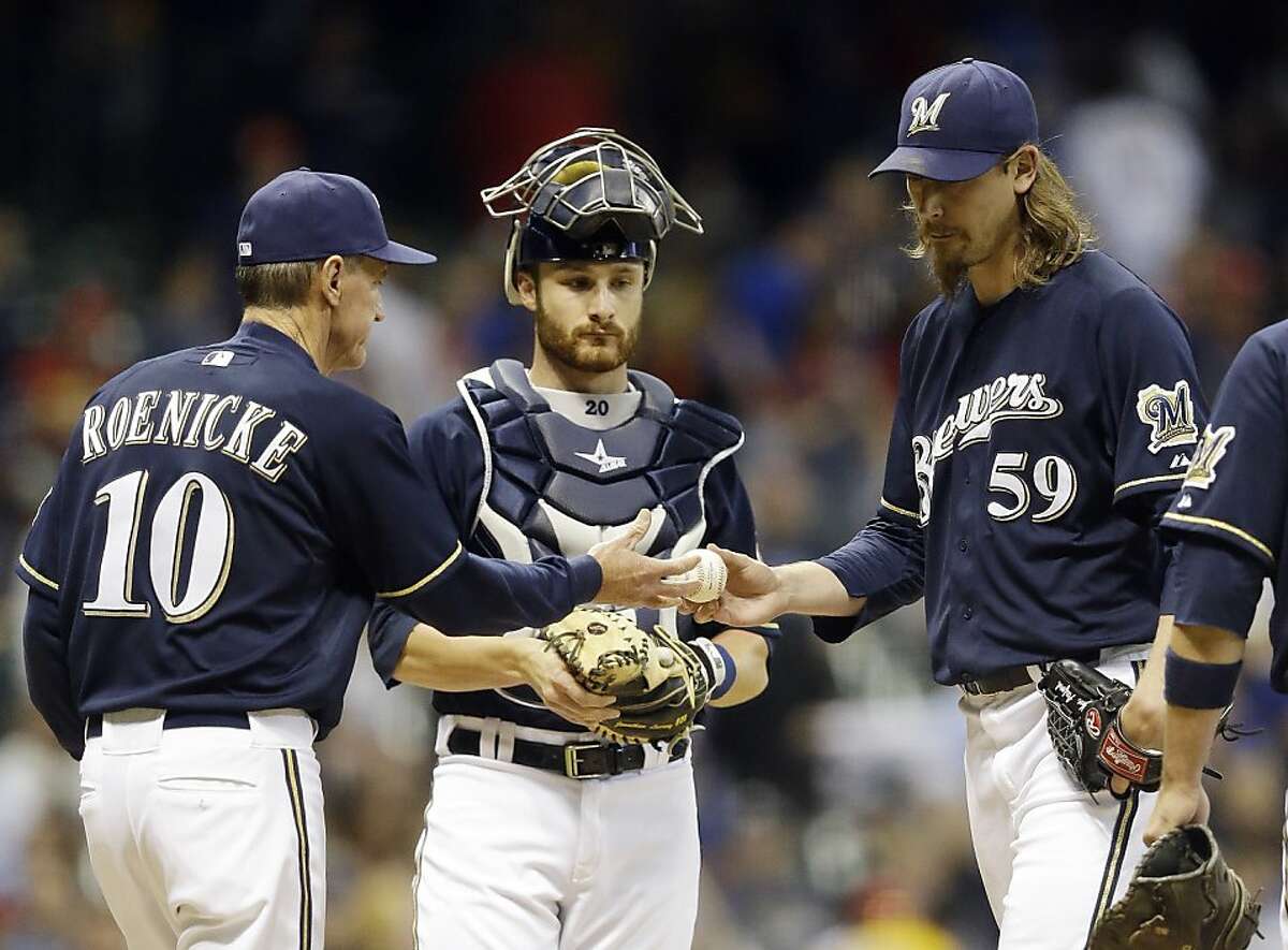 Milwaukee Brewers catcher Jonathan Lucroy watches as manager Ron Roenicke (10) takes relief pitcher John Axford (59) out during the ninth inning of a baseball game against the Chicago Cubs Friday, May 11, 2012, in Milwaukee. The Cubs scored three runs in the inning. (AP Photo/Morry Gash)