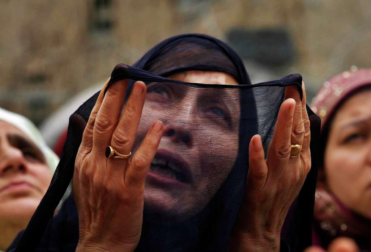 A Kashmiri Muslim woman prays as a head priest, unseen, displays a relic, believed to be a hair from the beard of the Prophet Mohammad, during special prayers on the death anniversary of Abu Bakr Siddiq, the first Caliph of Islam at Hazratbal Shrine on the outskirts of Srinagar, India, Monday, May 14, 2012. (AP Photo/Mukhtar Khan)