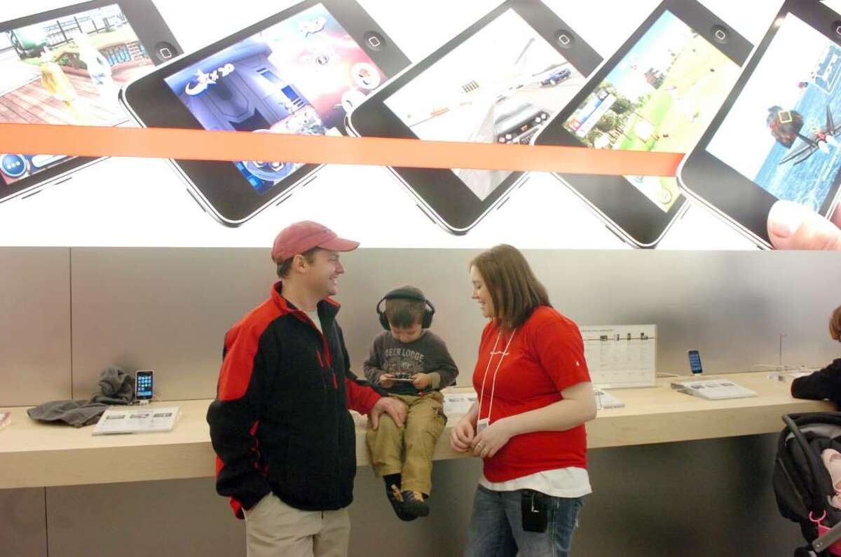 Thomas Johnson, 3, navigates the iPod Touch perched on the bar as his dad, Max, chats with Apple Specialist Allie in the new Greenwich Avenue Apple Store Saturday morning, Nov. 21, 2009.