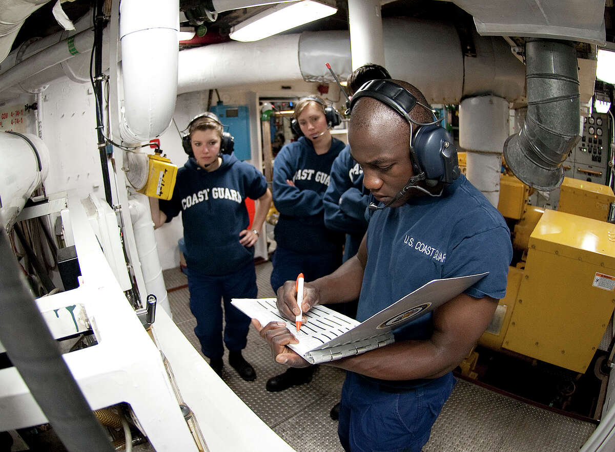 Orlando Morel reviews a logbook in the generator room of the Coast Guard Cutter Eagle. On Wednesday, he will graduate from the Coast Guard Academy.