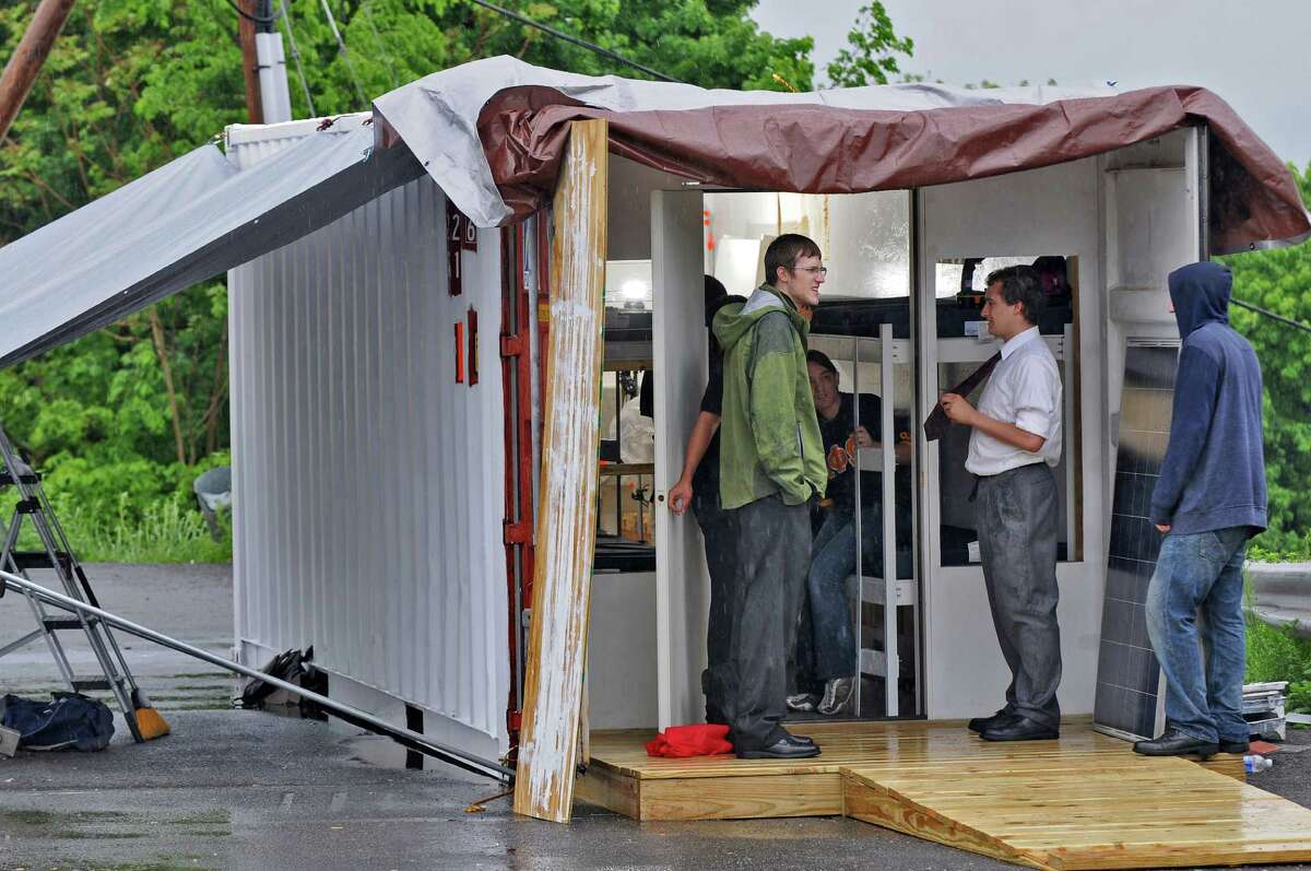 Members of the RPI student group Engineers for a Sustainable World are converting a used 20 foot long steel shipping container into living quarters that will be sent for use by the Orphanage of Good Will in Haiti, on Tuesday May 15, 2012 in Troy, NY. A solar panel waits to be installed, at right, to provide power for the unit. The unit will be finished when it arrives in Haiti. (Philip Kamrass / Times Union )