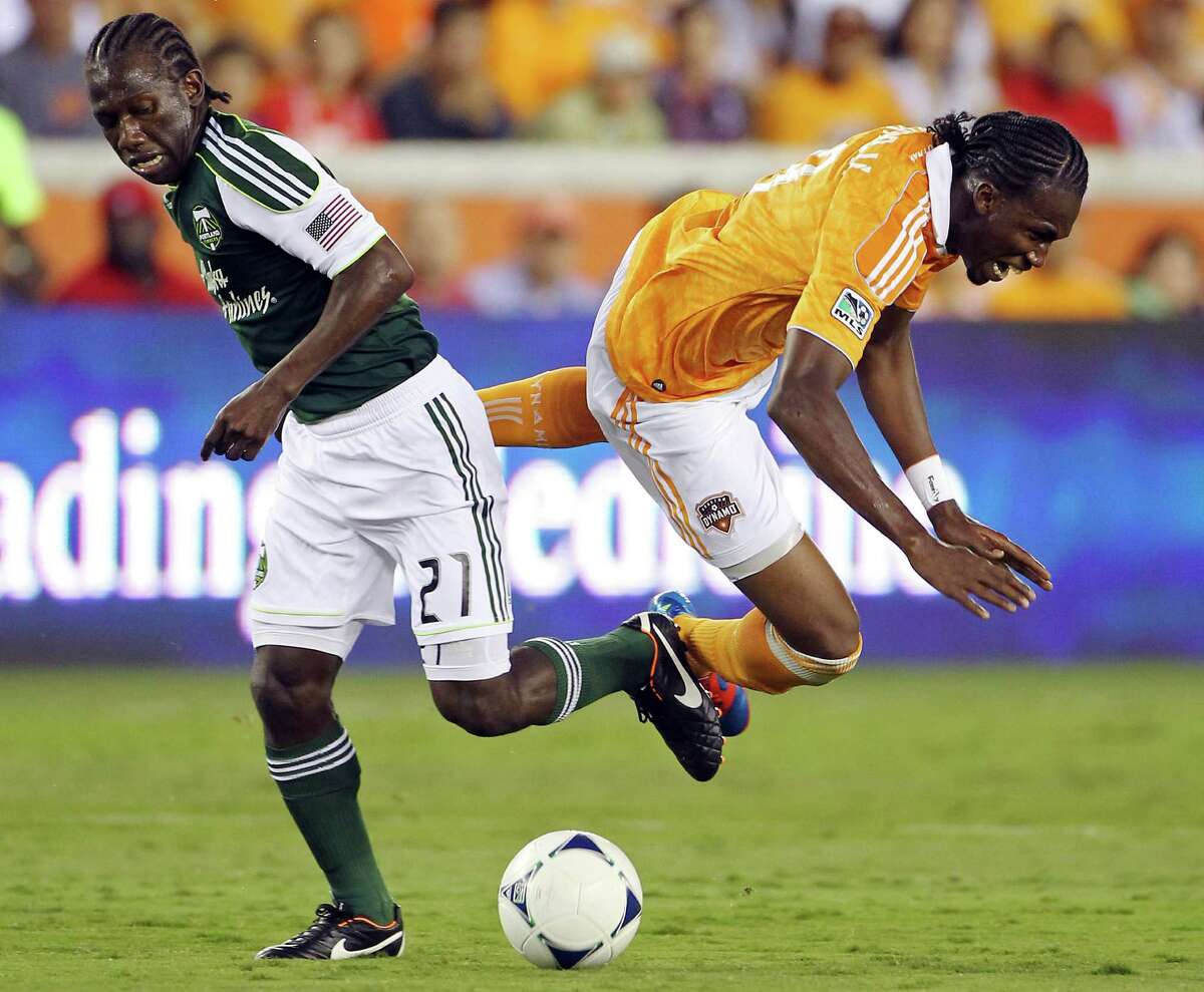 The Dynamo's Mac Kandji, right, gets the worst of a collision with the Timbers' Chris Taylor.