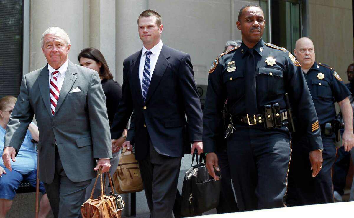 Former HPD officer Andrew Blomberg center, walks out of the Harris County Criminal Justice Center with his attorney Dick DeGuerin left, after being not guilty of official oppression in the videotaped beating of 15-year-old Chad Holley Wednesday, May 16, 2012, in Houston.
