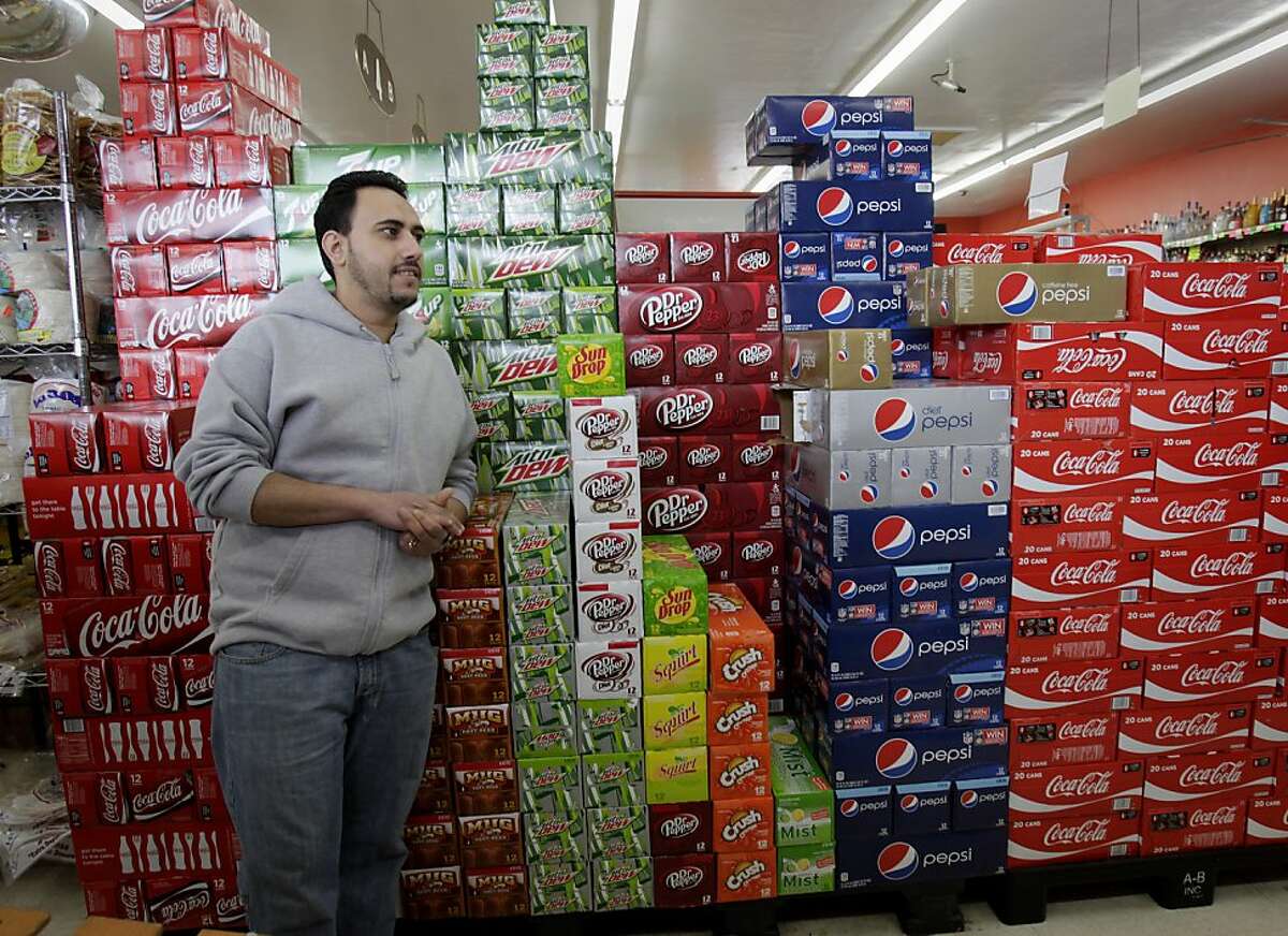 Omar Nassar, manager of the Richmond Food Center, stands in front of a mountain of soda varieties. He figures he will lose some business if the soda tax passes and people will go out of Richmond for their soda purchases. The Richmond City Council has approved a measure for the November ballot which would ask voters to approve a tax on soda and sugary drinks, the first such tax in the nation.