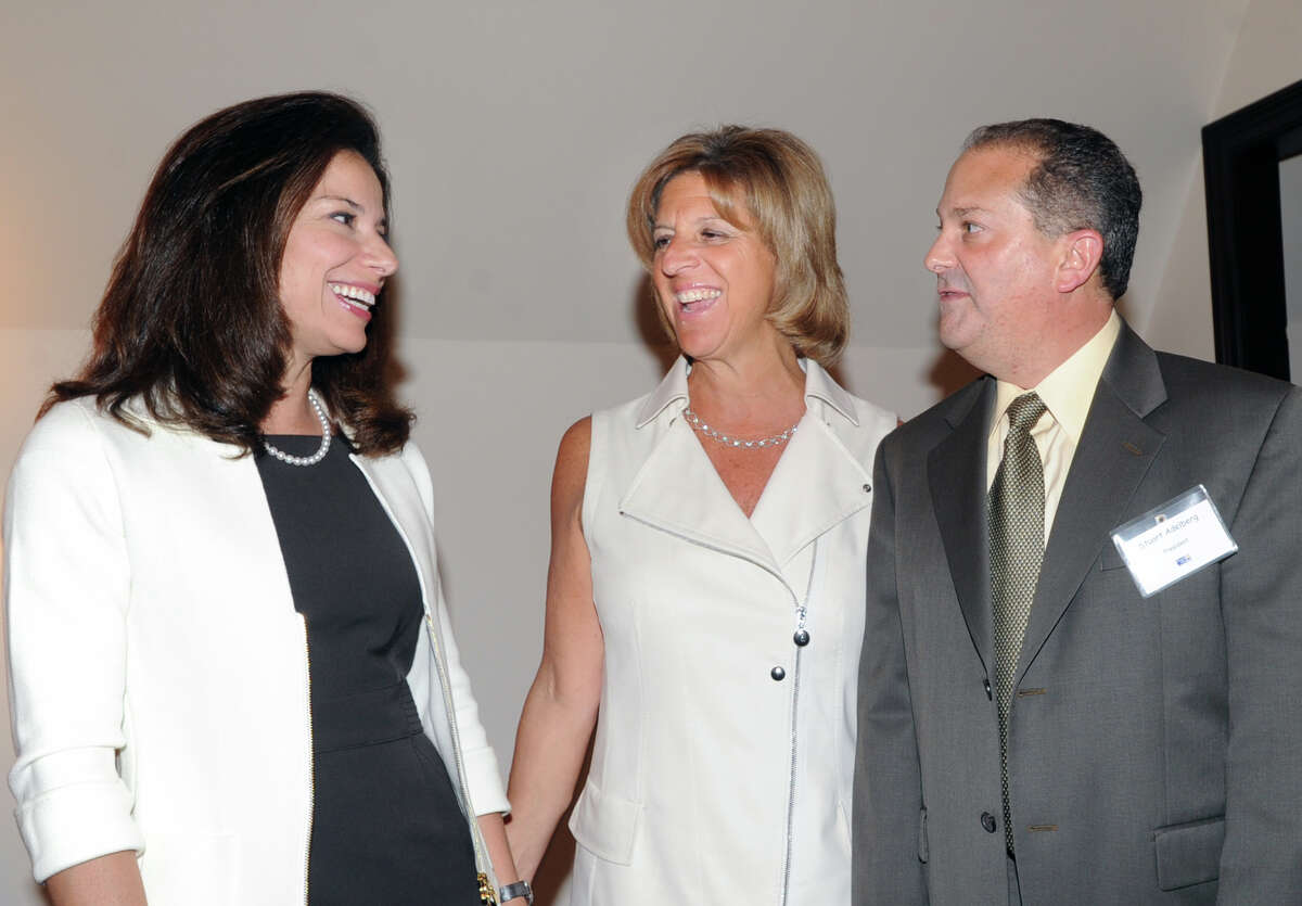 From left, Giovanna Miller and Terry Lamantia Cataldo, both of Greenwich, speak with Greenwich United Way President Stuart Adelberg, during a meeting at the Milbrook Club in Greenwich, Thursday night, May 3, 2012.