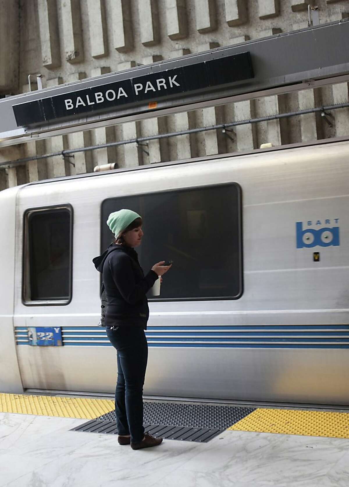 A BART rider looks at her phone before getting on BART at the Balboa Park Station in San Francisco, Calif., Tuesday May 15th, 2012.