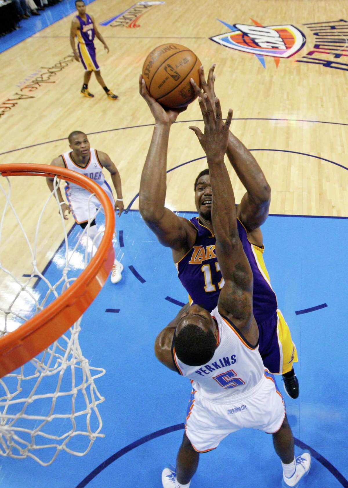 Los Angeles Lakers center Andrew Bynum, center, shoots between Oklahoma City Thunder guard Russell Westbrook, left, and center Kendrick Perkins (5) in the third quarter in Game 2 of an NBA basketball playoffs Western Conference semifinal, in Oklahoma City on Wednesday, May 16, 2012. Oklahoma City won 77-75. (AP Photo/Sue Ogrocki, Pool)