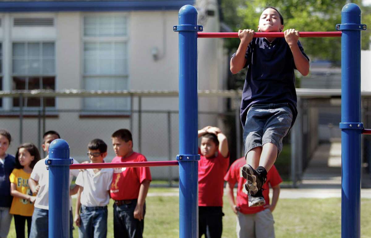Student Frank Precella demonstrates a pull-up on the launch of the new Project Fit America fitness playground at Eugene Field Elementary School on Thursday, May 17, 2012, in Houston. On National Fitness Month, Project Fit America launched a model school program at Eugene Field Elementary to promote and encourage physical fitness and healthy lifestyles to students, parents and staff.