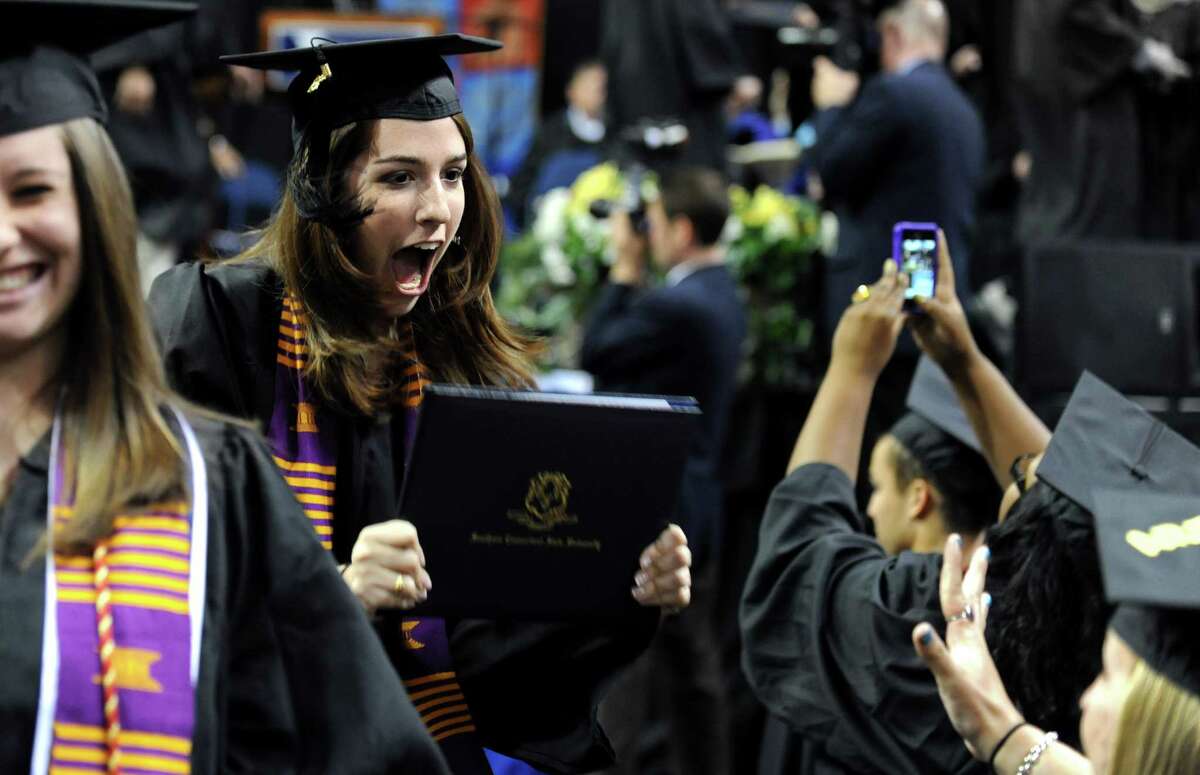 Graduate Brianna Micanovic, of Shelton, shows off her diploma during Southern Connecticut State University's commencement ceremony Friday, May 18, 2012 at the Webster Bank Arena in Bridgeport, Conn.