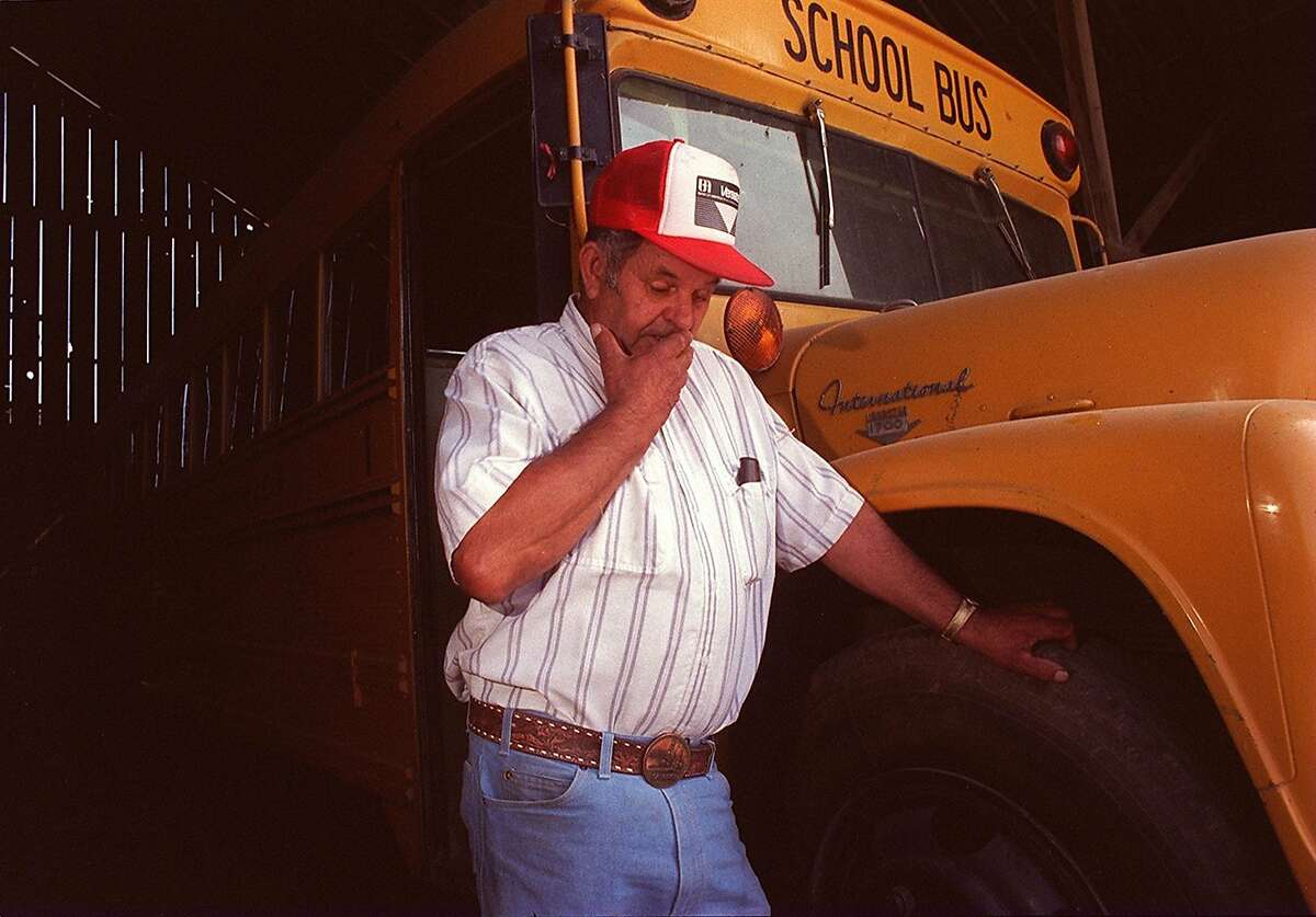 File - In this 1992 file photo, Frank Edward Ray stands in Chowchilla, Calif., by the bus from which he and 26 students were kidnapped. Ray, the school bus driver hailed as a hero for helping 26 students escape after three men kidnapped the group and buried the entire bus underground in 1976 has died. He was 91. (AP Photo/Merced Sun Star, File)
